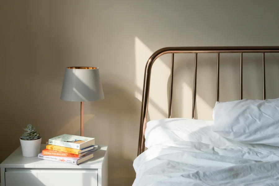De Duinkamer: tweepersoonsbed met koperen bedframe en een nachtkastje met lamp